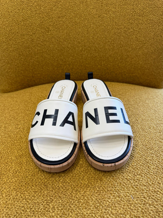 CHANEL
Ivory/Black Lambskin Leather Logo Mule Slides