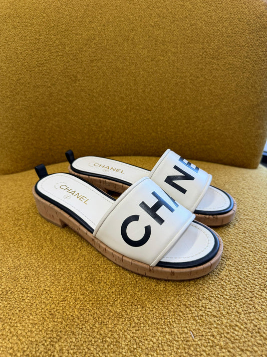 CHANEL
Ivory/Black Lambskin Leather Logo Mule Slides