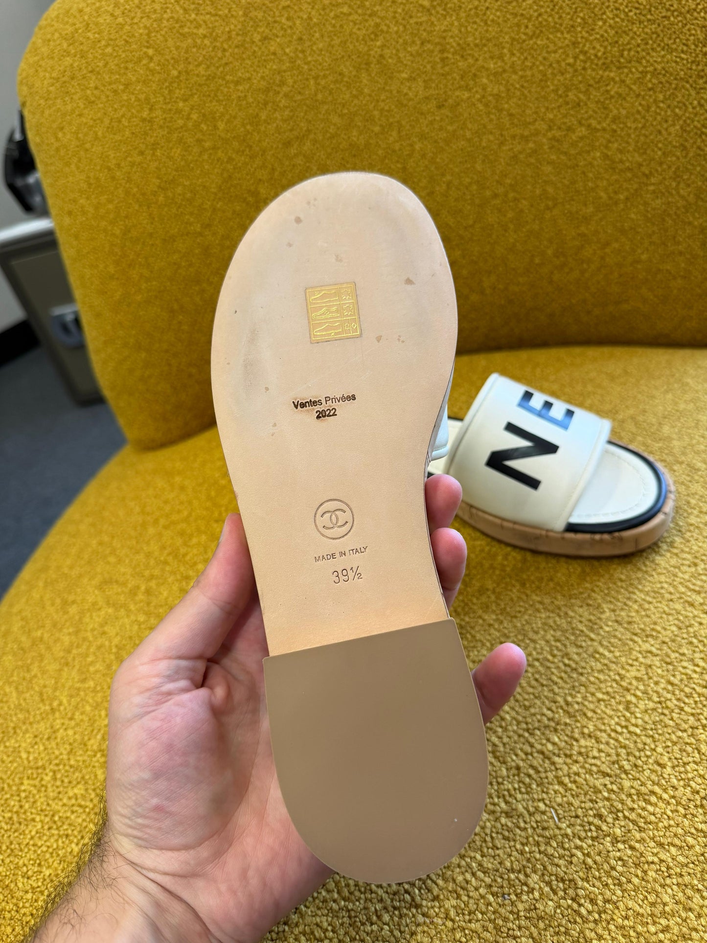 CHANEL
Ivory/Black Lambskin Leather Logo Mule Slides